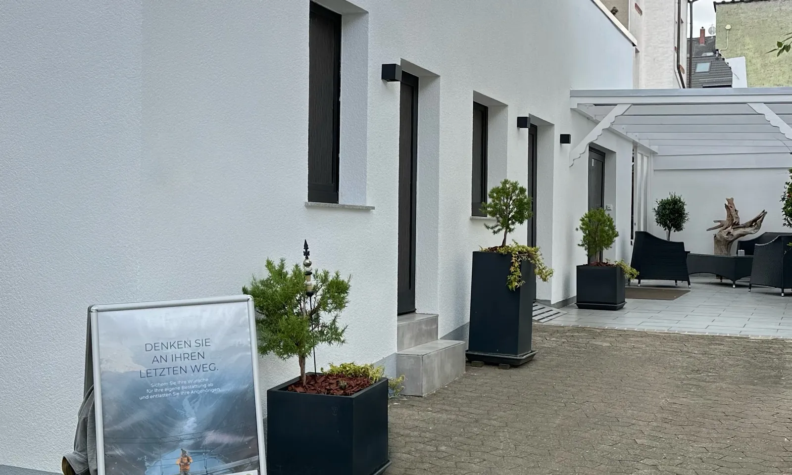Der Eingangsbereich von Dechert Bestattungen in Darmstadt mit bepflanzten Kübeln