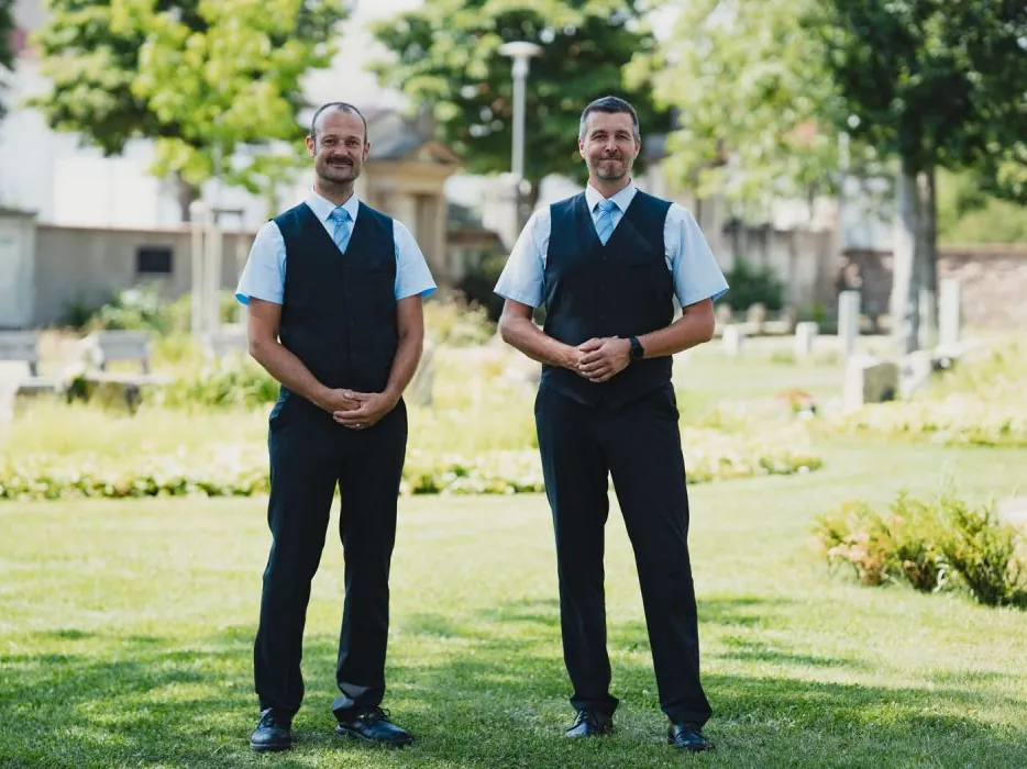 Zwei Mitarbeiter von Falk & Hörr auf einer Friedhofswiese in Pfungstadt